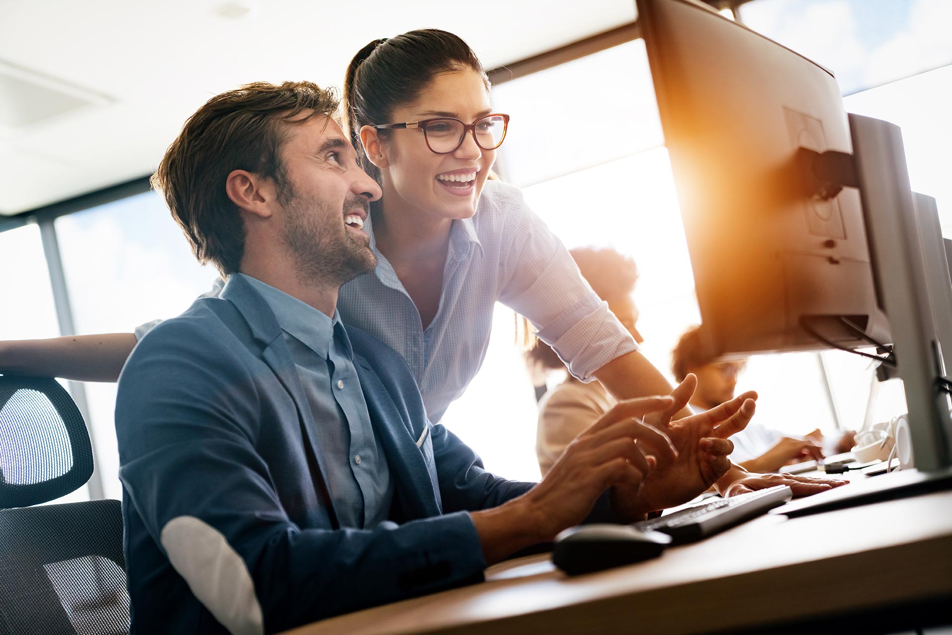 man and woman working on IT solutions smiling